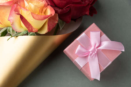 Pink gift box and  blossom rose. Celebration concept, greeting objects flat lay