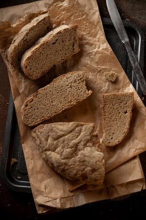 Low key food photography. Black rustic bread on dark background