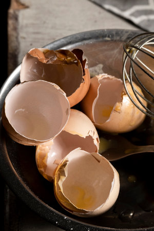 Cooking with eggs, cracked egg shells, used kitchen utensils on the table