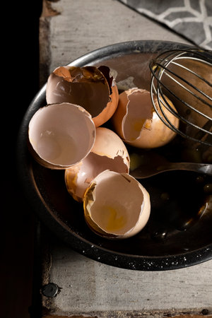 Cooking with eggs, cracked egg shells, used kitchen utensils on the table