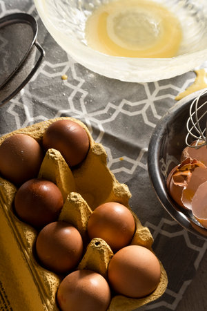 Cooking with eggs, cracked egg shells, used kitchen utensils on the table
