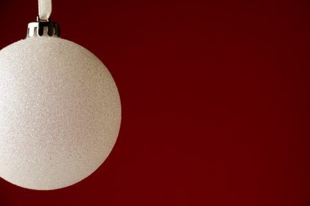Christmas minimal decor background, royal red color background with single white ball decoration, vertical view with space for textの写真素材