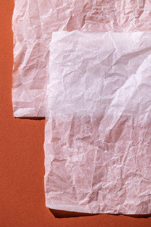 Warm orange background with a white empty sheet of paper. Top view, cozy minimal style in warm colors, space for text.の写真素材