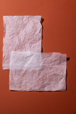 Warm orange background with crumpled white paper. Top view, cozy minimal style in warm colors, space for text.の写真素材