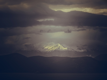 Panoramic view of snow covered Parnassus Mountains on a sunny day from the island of Evia, Greece