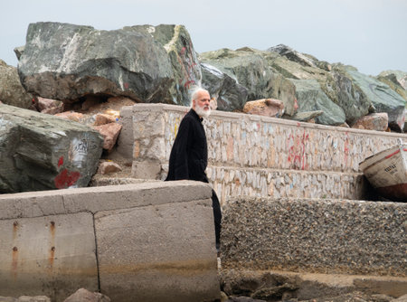Portrait of an old man on the seashore in winterの写真素材
