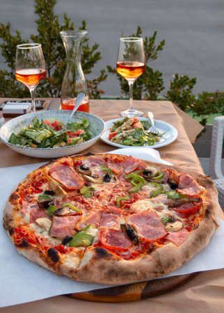 Pizza with ham, olives and arugula on the tableの写真素材