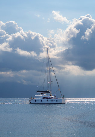 Yacht in the sea on a background of blue sky with clouds