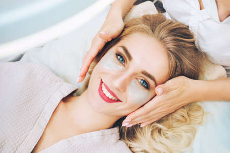 Cosmetologist applaying anti-aging eye gel pads. The concept of anti-agingの写真素材