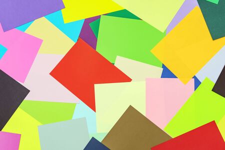 A multi-colored kaleidoscope of colored sheets of paper scattered chaotically in a controlled, beautiful chaos style.の写真素材