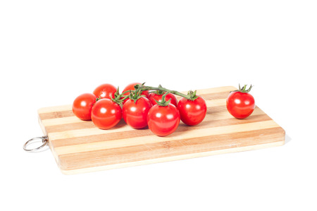 cherry tomatoes on cutting board isolated on whiteの写真素材