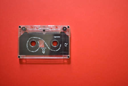 A black cassette on a red background