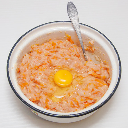 minced meat with grated carrots and egg in a bowlの写真素材