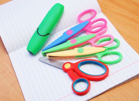 colorful scissors lay on notebooks in lineの写真素材