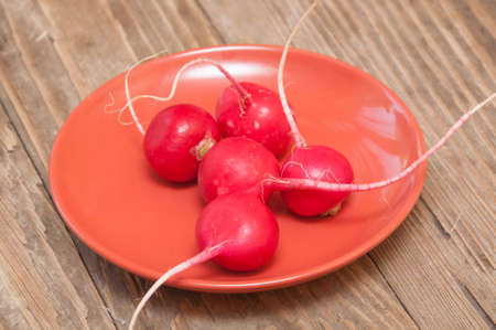 radishes in a saucer on a wooden backgroundの写真素材