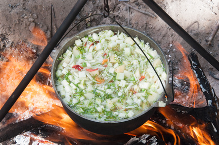 vegetables prepared in a cauldron over a fire on the natureの写真素材
