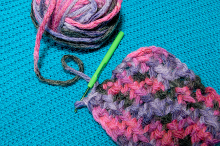 multicolor ball of yarn and knitting a blue knitted backgroundの写真素材