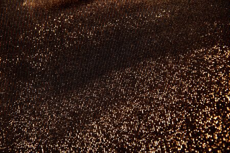 the background dark shiny brown with orange fabricの写真素材
