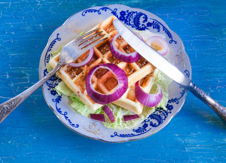 Belgian waffles on a plate on a blue backgroundの写真素材