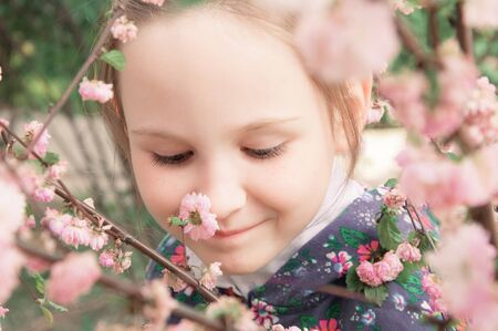Girl and pink flowers outdoors in springの写真素材