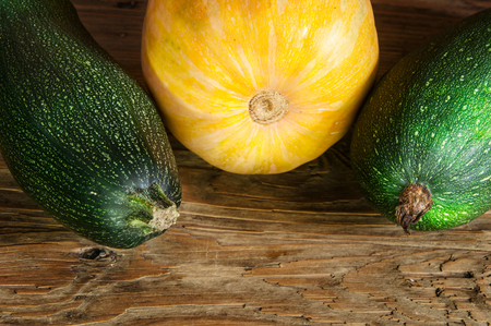 Vegetable marrows and pumpkin on a wooden tableの写真素材