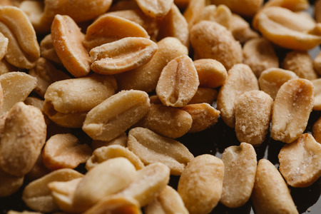 bunch of kernel peanuts on a blurred background closeup.の写真素材
