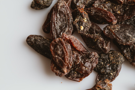 dark dried raisins close-up on a light background.