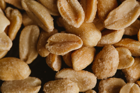 bunch of kernel peanuts on a blurred background closeup.の写真素材