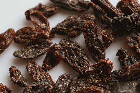 dark dried raisins close-up on a light background.の写真素材