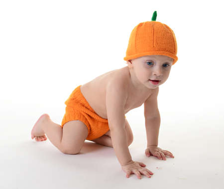 Child dressed as a pumpkin on a white backgroundの写真素材