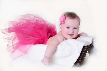 Little girl in a basket on a white backgroundの写真素材
