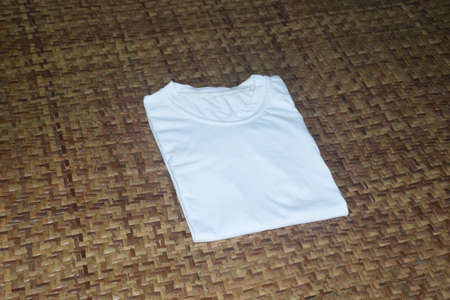White t-shirt on a bamboo background. Flat lay, top view.