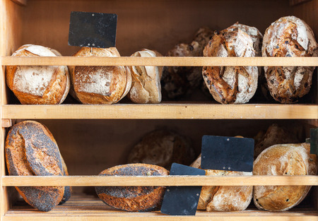 Variety of breads displayed on shelves in bakeryの写真素材