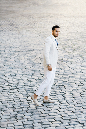 Portrait of stylish handsome young man with bristle standing outdoorsの写真素材