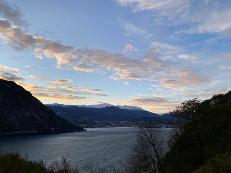 View of the mountains and lake Lugano, Switzerland. Evening view of the mountains at sunset. Cloudy...