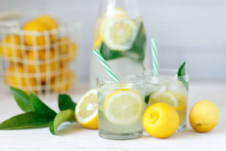 Fresh lemon lemonade with mint in bottle on kitchen table with ingredients. healthy nutrition diet concept. White background.の写真素材