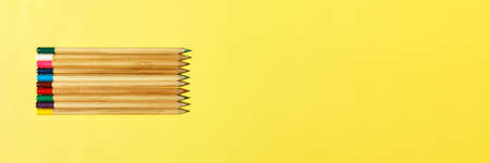 Bright mix colored wooden pencils in shape. Minimalistic geometric lines on yellow background . Top view, school or education concept, bannerの写真素材