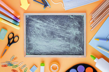 Back to school with school supplies, stationery, medical mask and notebook with empty space in...