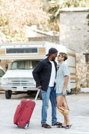 excited African American couple celebrating success, travel, overjoyed wife and husband received good news, online lottery win, approved mortgage loan, showing yes gesture. Nature flowering background.の写真素材