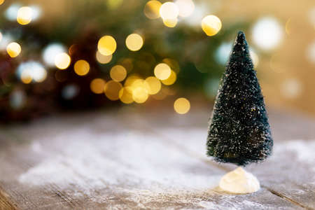 Christmas cookies in plate, festive tree and pine cones, bokeh light. Christmas sweets. Sugar powder poured onto the cookiesの写真素材