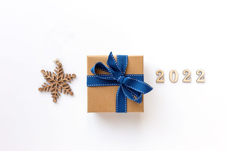Xmas 2022 composition with present box decorations, wooden snowflakes, fir tree branches. Merry...