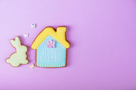 Happy Easter minimalistic background. Multicolored pastel easter cookies on a violet...