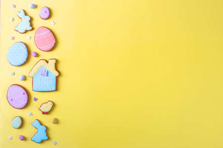 Happy Easter. Multicolored pastel easter cookies on a yellow background, various gingerbread glazed cookies , flat lay, view from above, blank space for greeting text, banner, flyer, couponの写真素材
