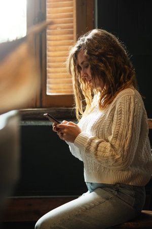 Portrait of young caucasian woman using mobile phone, communication, chatting. Happy female holding...