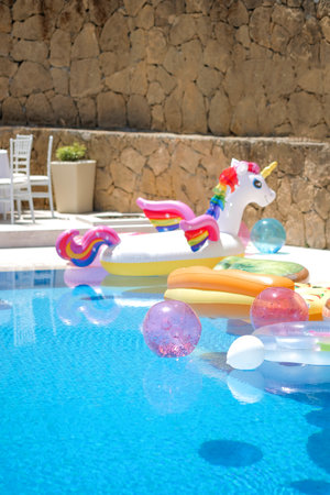Funny inflatable unicorn ring floating in swimming pool on sunny day. Swimming pool party concept.No peopleの写真素材