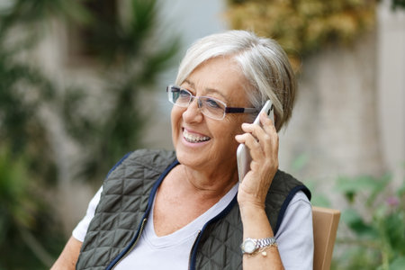 Cheerful senior woman talking on mobile phone . Elderly lady enjoying freedom and retirementの写真素材