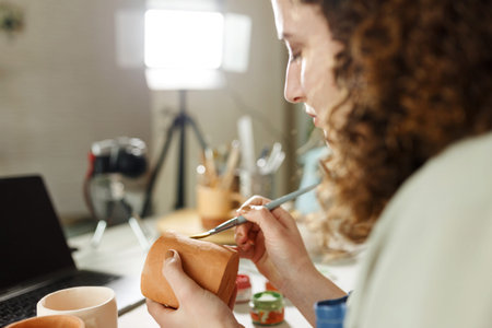 Females potter painting cup, making a vlog, recording online course, clay master class,lessons in...