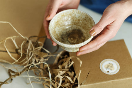 Entrepreneur sells dishes, plates and cups made of clay, ceramics online and packs them in boxes for...