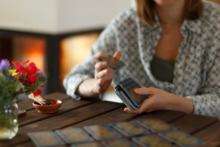 Fortune teller with tarot cards on table near burning candle.Tarot cards spread on table with magic...