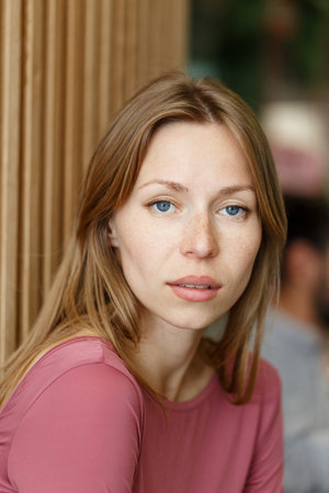 Happy young woman looking at the camera. Portrait of comfortable woman relaxing on armchair....